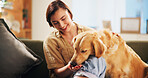 Dog, woman and happy with treat on sofa in home, relax and care with bonding, happy and trust in living room. Person, pet and golden retriever with snack, training and loyalty with food at apartment