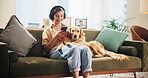 Dog, woman and phone on couch in home, relax and listen to music with mobile app, bonding and trust. Animal, pet and golden retriever with girl, smartphone and audio subscription with smile in lounge
