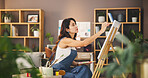 Artist, woman and painting for creative art, inspiration or design process for project in lounge. Brush, canvas and painter drawing with tools for hobby, color or sketch with talent for craft in home