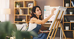 Artist, woman and painting in home for art, inspiration or design process for project in lounge. Brush, canvas and painter drawing with tools for hobby, color or creative sketch with talent for craft