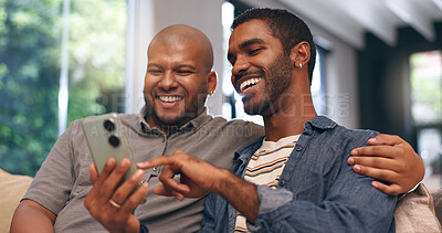 Buy stock photo Gay couple, men and smile on sofa with phone for social media, internet streaming or bonding with laugh. Lgbtq, home and smartphone for online joke, meme or website conversation with funny app