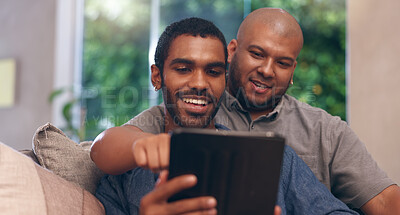 Buy stock photo Gay couple, men and smile on sofa with tablet for social media, internet streaming or bonding. Lgbtq, home living room and technology for online app, meme or website conversation with reading