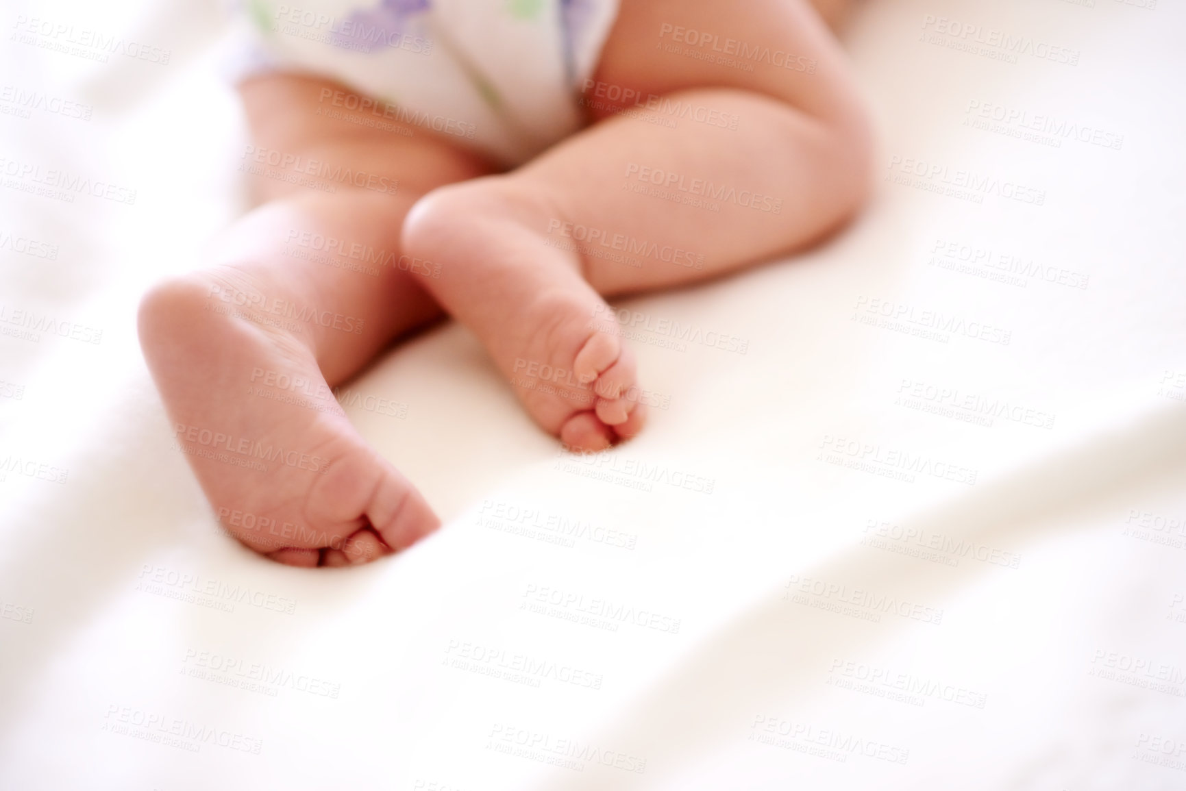 Buy stock photo Baby, legs and feet on sheet of bed with diaper for comfortable, delicate and growth in nursery. Body, peace and newborn with tiny toes on linen for future development, childhood and rest at home