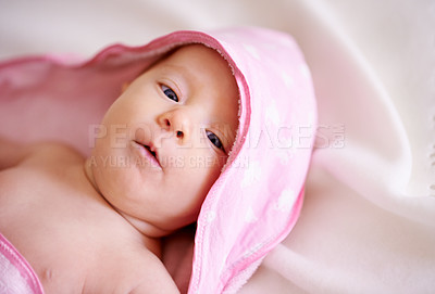 Buy stock photo Baby, face and child in hooded towel on bed for bathing, hygiene and morning routine for healthy development. Infant, kid or top view in crib with washing for skincare, body care or wellness in house