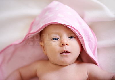 Buy stock photo Baby, face and hooded towel on bed for bathing, hygiene and morning routine for healthy development. Infant, kid and top view in nursery with washing for skincare, body care and wellness in home
