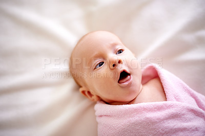Buy stock photo Blanket, wrap and baby with tongue out on bed for childhood development, comfortable and rest. Sweet, infant and top view with peace on sheet in nursery for healthy growth, cute and adorable at home