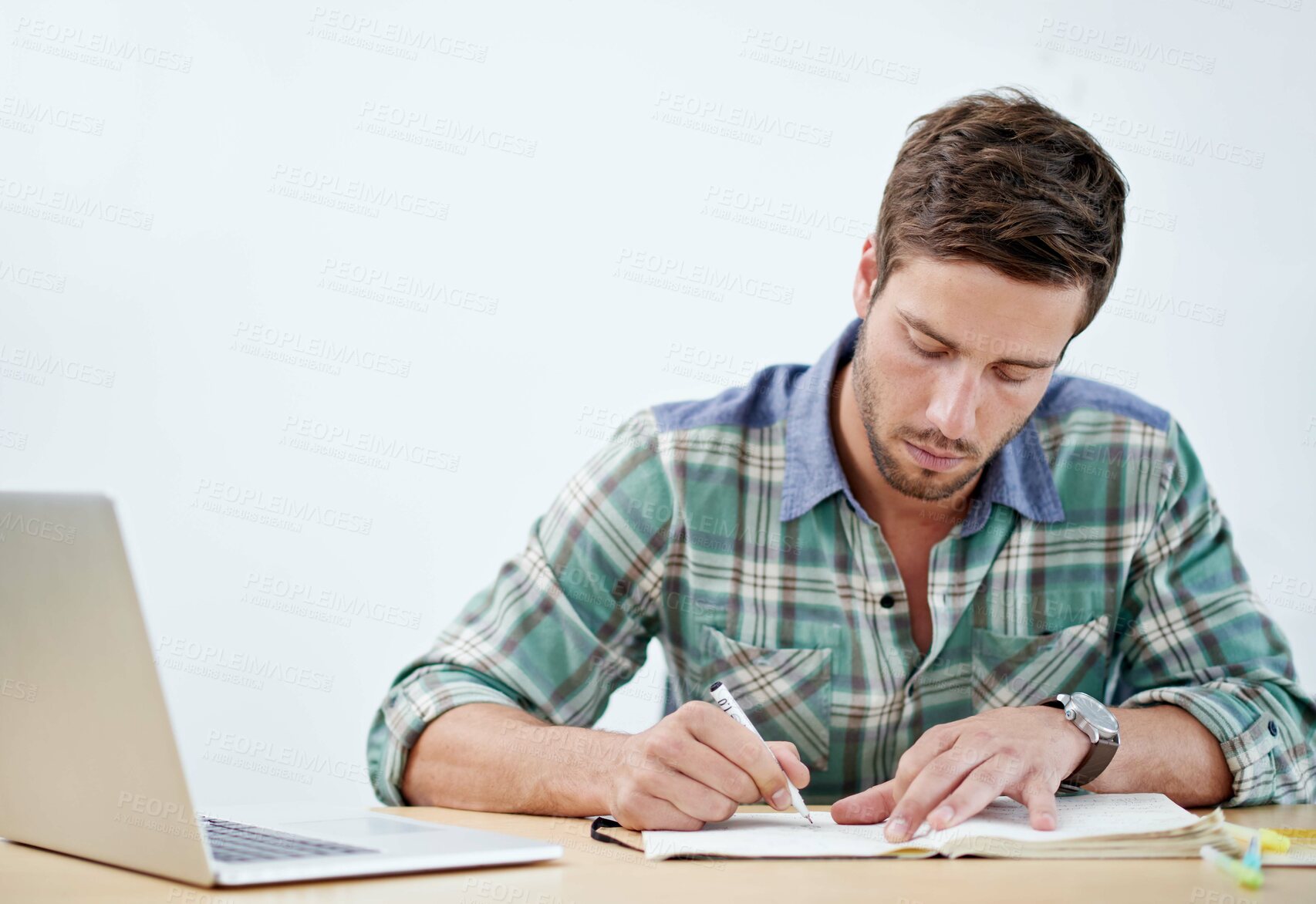 Buy stock photo Laptop, office and man with book at desk for project planning, research and schedule information. Creative, agency and male person with writing on paper for graphic design, drawing and sketching