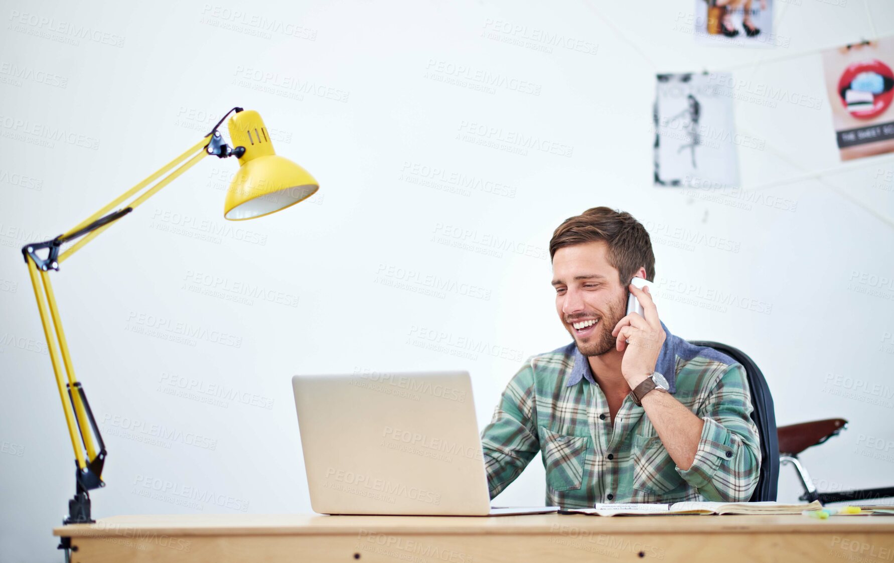 Buy stock photo Phone call, laptop and man at desk for creativity, magazine editing and communication in office. Male person, graphic designer and smartphone at table with computer, discussion and smile for success