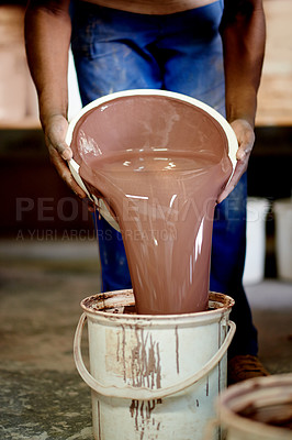 Buy stock photo Clay, liquid and hands of person pouring in pottery studio for creativity, ceramics and small business. Workshop, mud and employee for art and crafts with bucket for handmade product or design