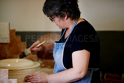 Buy stock photo Pottery, art and woman in studio for ceramic workshop, shape process or handmade design. Craft, hobby and mature artist with brush on clay, unique artwork and creative with sustainable small business