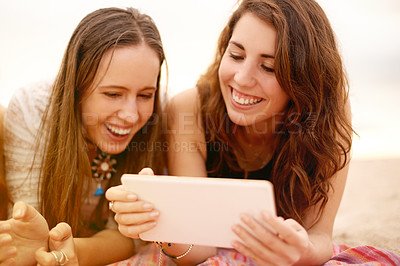 Buy stock photo Women, tablet and laugh with friends for social media, communication and beach picnic. Female people, smile and lying on blanket with digital technology for summer holiday, vacation or ocean post