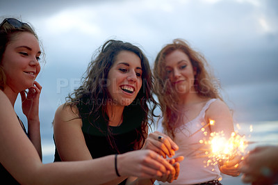 Buy stock photo Beach, sparklers and women with vacation, celebration and bonding together with reunion. New Years, ocean and people with fireworks, friends and happiness with summer holiday on tropical island 