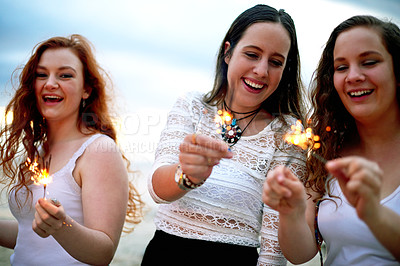 Buy stock photo Outdoor, celebration and girl friends with sparklers at party, event or festive occasion. Happy, portrait and group of women with firework sticks for festival, summer break or holiday together.
