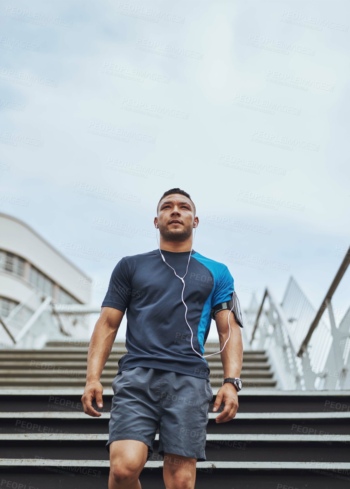 Buy stock photo Fitness, thinking and man on steps in city with health, wellness and earphones for streaming. Urban workout, body care and runner listening to music, podcast or app on stairs for morning exercise.