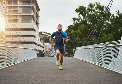 Buy stock photo Fitness, running and man on bridge with speed, health and wellness for muscle growth in city. Urban workout, body care and runner with challenge, development or training in street on morning exercise