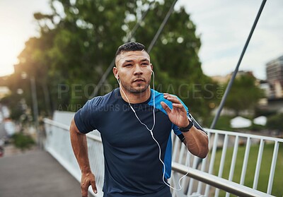 Buy stock photo Fitness, running and man on bridge with earphones, health and wellness for muscle growth. Urban workout, body care and runner listening to music, podcast or training in street for morning exercise