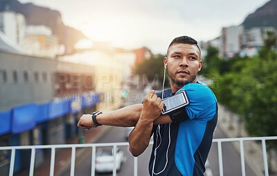 Buy stock photo Man, fitness and stretching arms outdoor for exercise, health and wellness with commitment. Athlete, mindset and warm up start for workout, training and sport performance with music or earphones