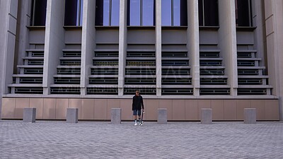 Buy stock photo Skateboard, sports and man in city for outdoor activity, exercise or skill development. Building, fitness and male skater athlete in urban town for hobby, training or workout for gen z culture.