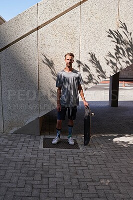 Buy stock photo Skateboard, portrait and fitness with man in city for culture, extreme sports and trick flip. Urban, hobby and street league with person training downtown for skating, ollie grind and balance 
