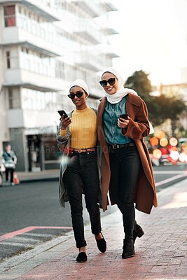 Buy stock photo City, muslim and phone with woman friends walking on sidewalk together outdoor for communication. App, smile and social media with happy Islamic people in urban town for contact, travel or shopping