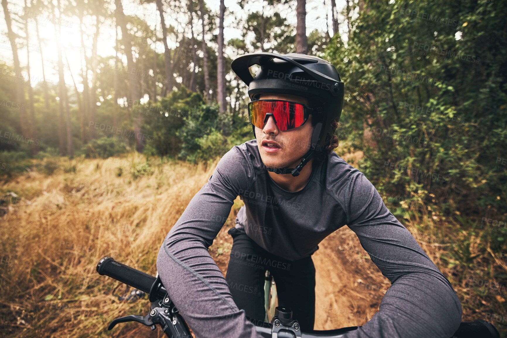 Buy stock photo Cyclist, bike and forest on adventure in nature for health, fitness and wellness. Man, bicycle and sunglasses in woods for travel with helmet on training, exercise or workout on trail by trees