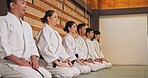 Discipline, kneeling and people in martial arts studio for practice, training or self defense class. Culture, karate and group of students with respect, honor or etiquette gesture to master in dojo.