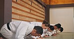 Bow, respect and people in martial arts studio for practice, training or self defense class. Culture, karate and group of students with greeting or etiquette gesture to master in dojo for honor.