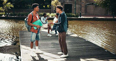 Buy stock photo People, students and campus for textbook discussion, outdoor and friends talking on education. Men, academy and support with university science or chemistry module, speaking and study at college park