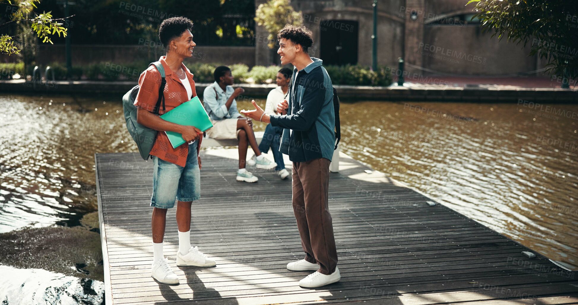 Buy stock photo People, students and campus for textbook discussion, outdoor and friends talking on education. Men, academy and support with university science or chemistry module, speaking and study at college park