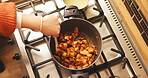 Hands, pot and cooking chicken in kitchen, stove and heat for soup, ingredients and nutrition in home. Person, chef and meal prep with food, diet and above with stirring, recipe and meat at house