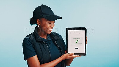 Buy stock photo Black woman, smile and screen of tablet for delivery, logistics and customer service in studio. Courier, person and check mark for distribution, food order status and schedule on blue background