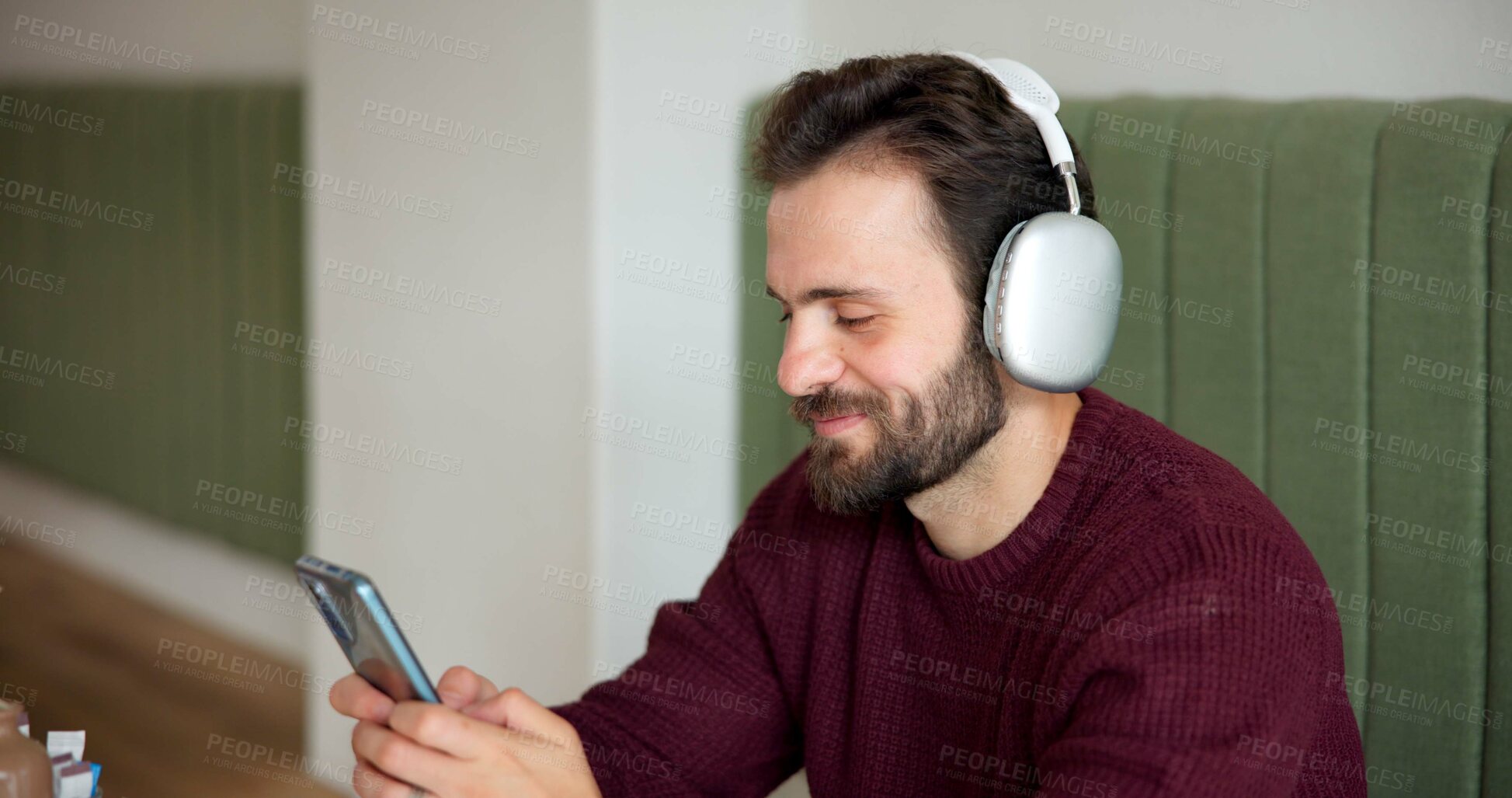 Buy stock photo Man, headphones and phone in cafe for music, social media or typing in dating app. Customer, coffee shop and cellphone in restaurant for audio, communication or online networking with podcast