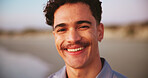 Portrait, happy and man on beach outdoor for summer vacation, tropical travel and weekend break. Smile, male person and ocean for holiday destination, seaside getaway and adventure for island trip