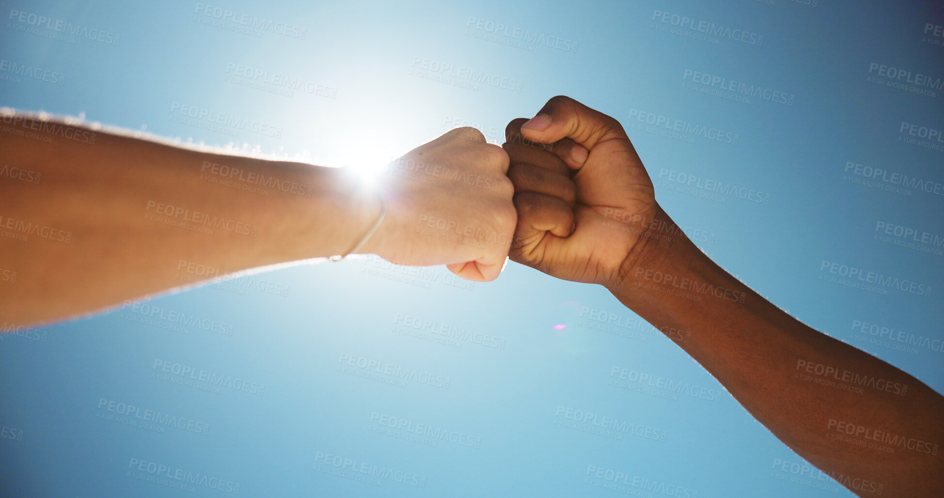 Buy stock photo People, fist bump and teamwork with blue sky for gratitude, appreciation or thank you in sunlight. Closeup, friends or touch with trust or lens flare below for commitment, greeting or agreement
