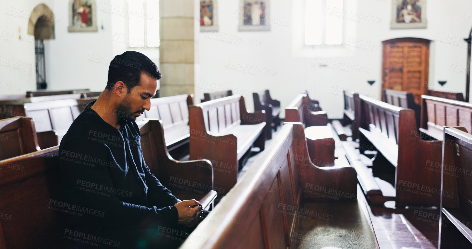 Buy stock photo Church, man and prayer for religion with rosary for faith, respect or worship God for forgiveness. Christian, chapel and person praying for hope, holy spirit and ask Jesus for guidance or blessing