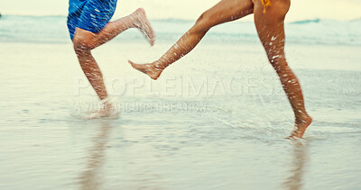 Buy stock photo Legs, splash and water with people at beach for playful, summer vacation and adventure. Travel holiday, bonding and freedom with closeup of feet of friends outdoors for social, seaside and care