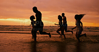 Buy stock photo Silhouette, running and people at ocean for sunset, freedom and excited on summer vacation. Friends, energy and playing at beach space for travel holiday, adventure and splashing in water for fun