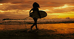 Silhouette, sunset and person with surfboard, beach and adventure for surfer in water, back and holiday. Summer vacation, travel and woman with fitness for sport, evening and hobby in nature or ocean