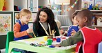 Education, kids and painting with teacher for art, creative talent and motor skill development in preschool class. Learning, students drawing and help happy children in lesson with brush for color