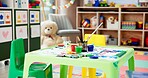 Kindergarten, table and empty classroom with paint for childhood development, art and crafts at school. Colorful, interior or equipment for drawing, creative lesson or mural activity at elementary