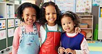 Happy girls, portrait and kindergarten with hug for friendship, education or fun learning together. Face, kids or children with smile or apron for creativity, art and crafts in elementary classroom