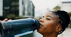 Black woman, drinking water and hydration outdoor for health, wellness and electrolyte liquid with fitness. Bottle, aqua or mineral beverage for exercise, nutrition and healthy with thirst in city