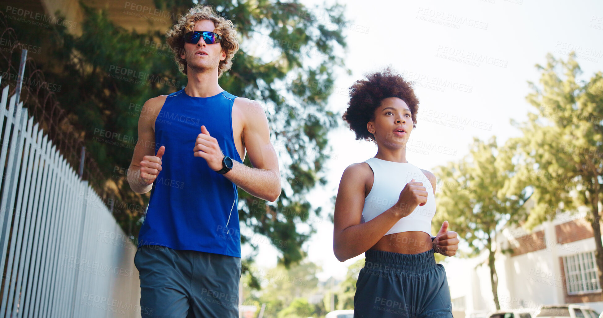 Buy stock photo Couple, exercise and running for workout in city, cardio together with fitness and wellness. Below interracial people,  training or sports challenge with team, urban and athlete partners outdoor
