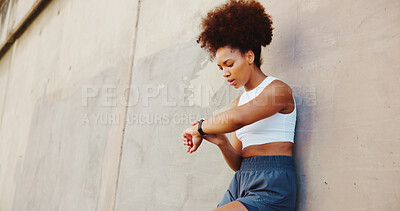 Buy stock photo Fitness, woman and smart watch in city for time, tracking progress or cardio assessment in app. African runner, break or tech at wall for stopwatch, challenge update or training notification at space