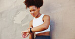 Fitness, woman and smart watch at wall for time, tracking progress or cardio assessment in app. African runner, below or tech in city for stopwatch, challenge update or training notification at space