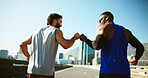 Happy men, back and running with fist bump in city for workout, exercise or training on road. Active, male people or runners with touch for sport, marathon or outdoor sprint together in an urban town