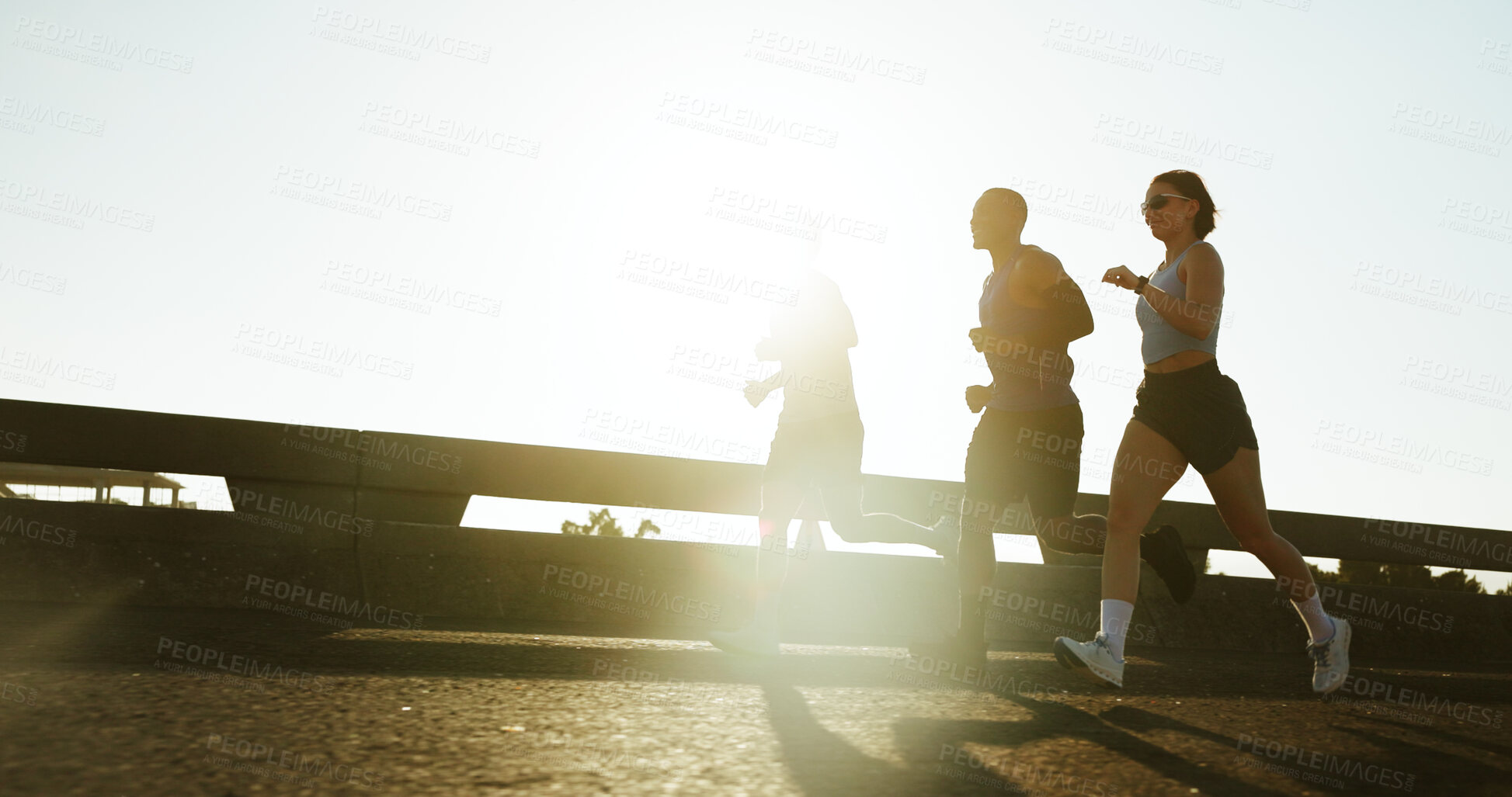 Buy stock photo People, running or fitness with sunshine in city for workout, exercise or training on road. Active group, friends or runners with bridge for sport marathon or outdoor sprint together in an urban town