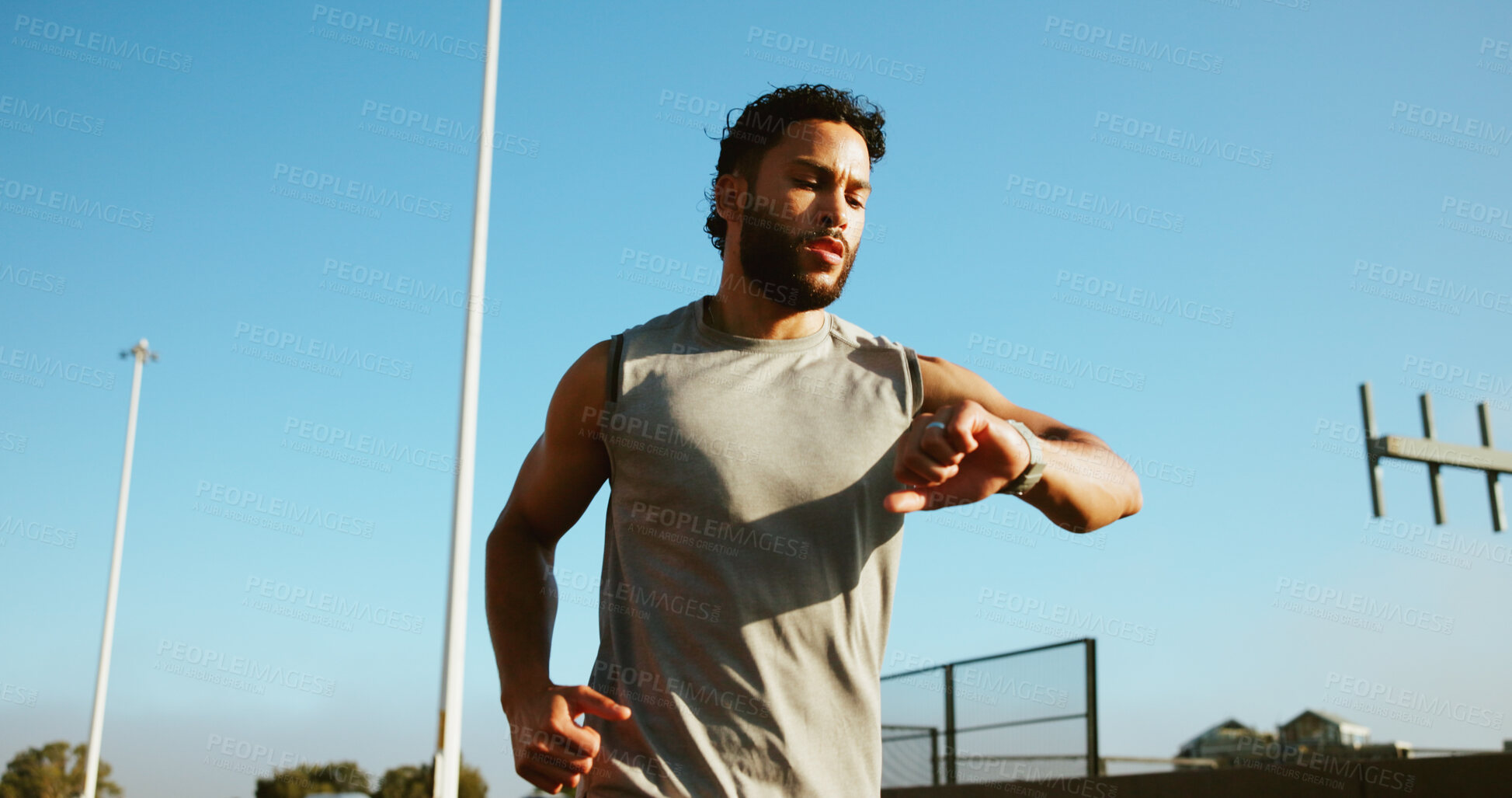 Buy stock photo Man, fitness and running with smart watch in city for workout app, exercise or tracking performance. Active, male person or runner checking wristwatch for steps, calories or monitoring heart rate