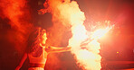 Excited, night and woman in celebration with fireworks for outdoor party, New Year or social event. Burn, holiday vacation and happy female person with fire art, smoke and flare for sparkle lights