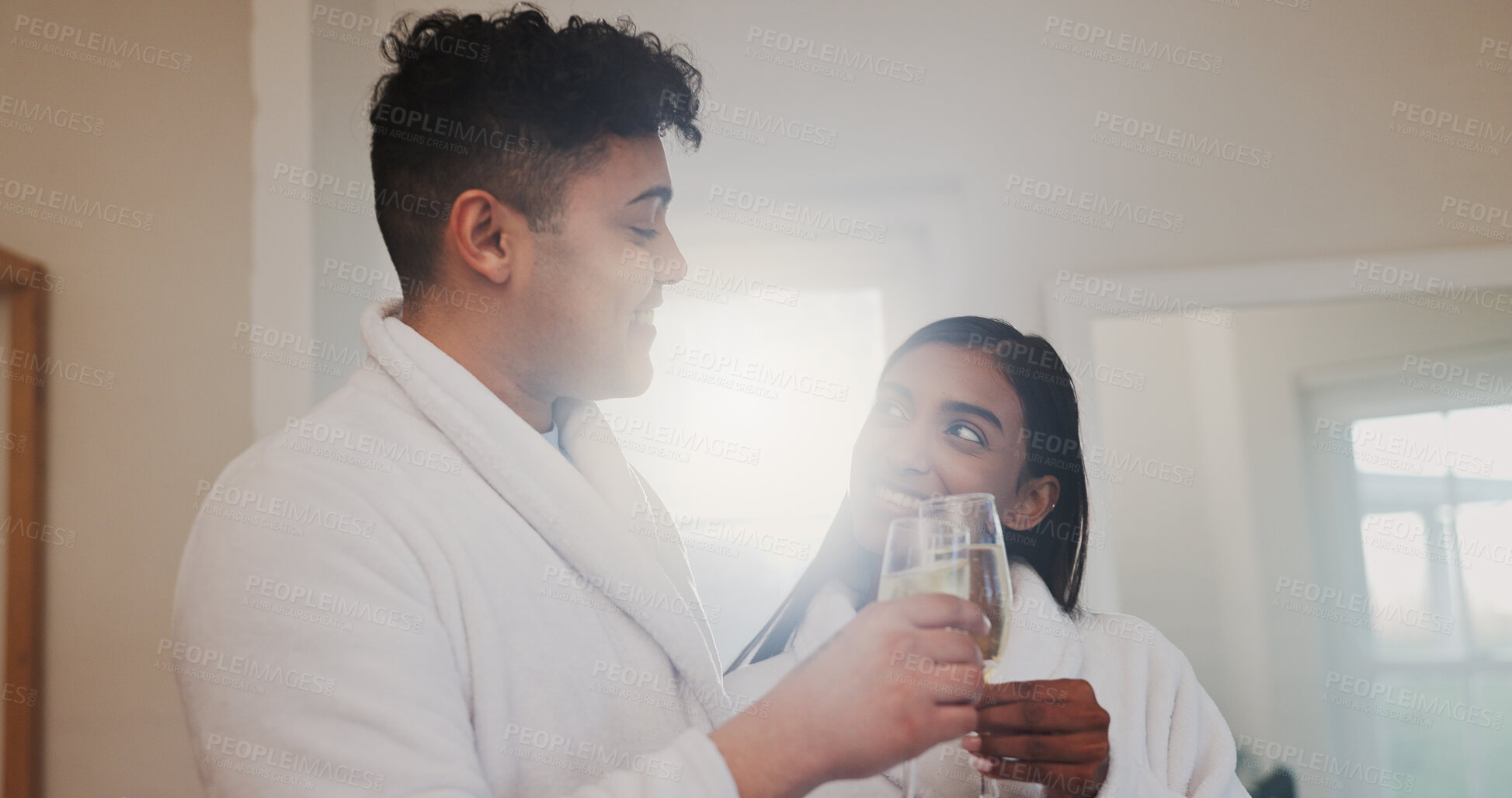 Buy stock photo Couple, champagne and toast with happiness for anniversary, honeymoon or holiday accommodation. Love, bonding and commitment with drinks for cheers, interracial people and vacation getaway in hotel